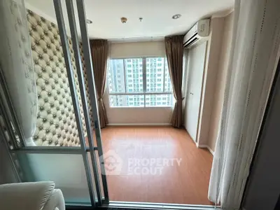 Spacious bedroom with large windows and elegant curtains in modern apartment.
