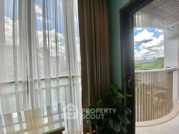 Stunning balcony view with floor-to-ceiling windows and lush greenery.