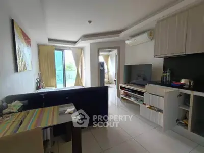 Modern living room with open layout and balcony access, featuring sleek furniture and contemporary decor.