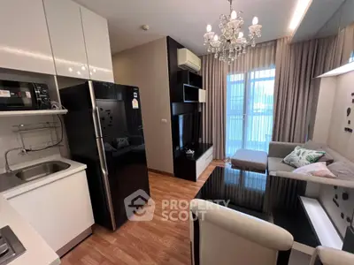 Modern living room with sleek kitchen and elegant chandelier in stylish apartment.