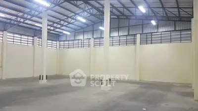 Spacious industrial warehouse with high ceilings and ample natural light.