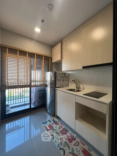 Modern kitchen with sleek cabinets and stainless steel fridge in bright apartment