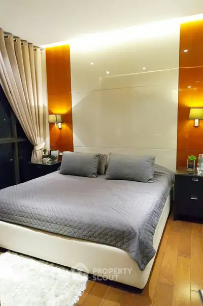 Luxurious bedroom with modern decor and ambient lighting, featuring a plush bed and elegant furnishings.
