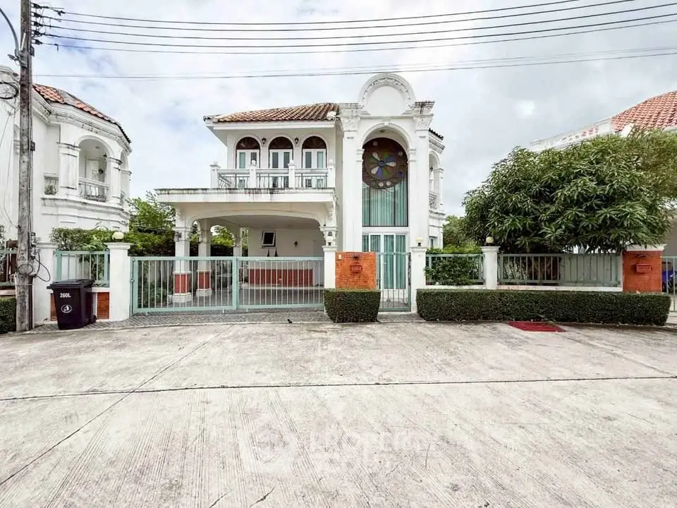 Elegant two-story house with unique architectural design and spacious driveway.
