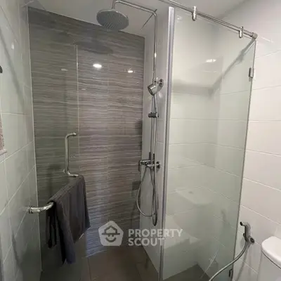 Modern bathroom with glass shower enclosure and sleek fixtures.