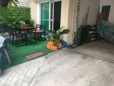 Charming outdoor patio with dining set and lush greenery, perfect for relaxation and entertaining.
