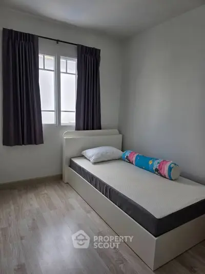 Cozy bedroom with single bed and window, perfect for a minimalist lifestyle.