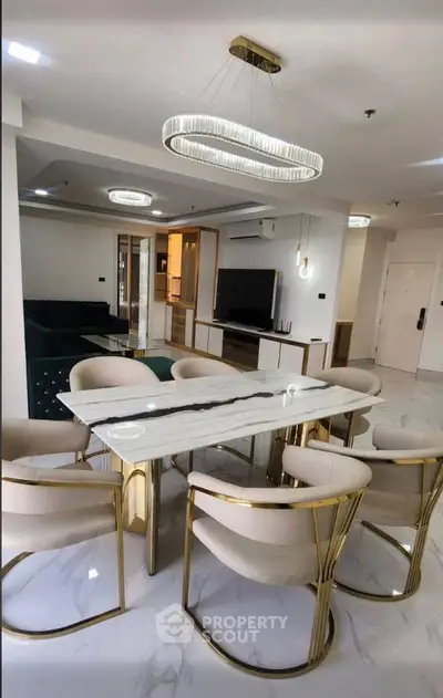 Luxurious modern dining area with elegant marble table and plush chairs in a stylish open-concept living space.