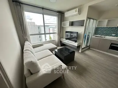 Modern living room with large window and open kitchen layout