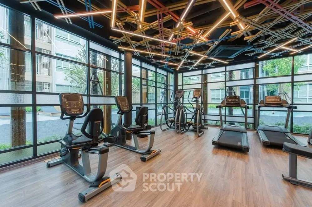 Modern gym with state-of-the-art equipment and stylish lighting in a residential building.