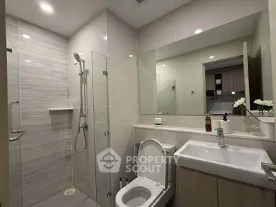 Modern bathroom with sleek fixtures and glass shower in contemporary home.