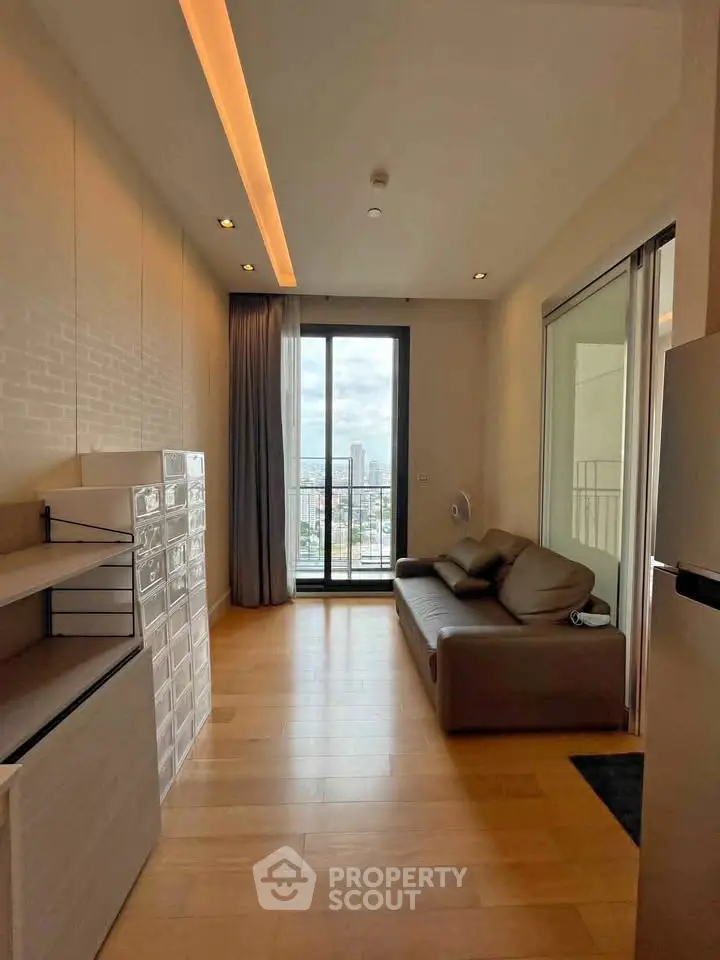 Modern living room with city view, featuring sleek furniture and floor-to-ceiling windows.