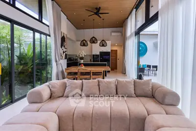 Luxurious open-plan living room with high ceilings and modern decor, featuring a plush sofa and elegant dining area.