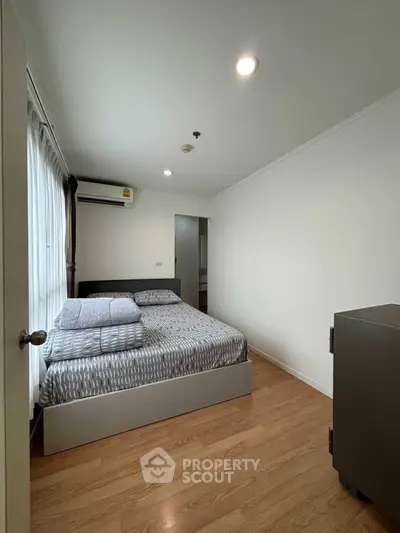 Cozy bedroom with modern decor and natural light in a stylish apartment.