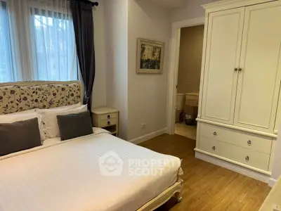 Elegant bedroom with classic decor and ensuite bathroom, featuring a cozy bed and stylish wardrobe.
