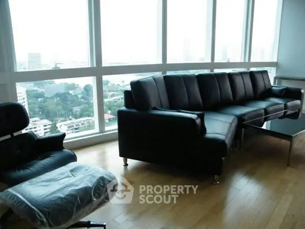 Luxurious living room with panoramic city view and modern leather furniture.