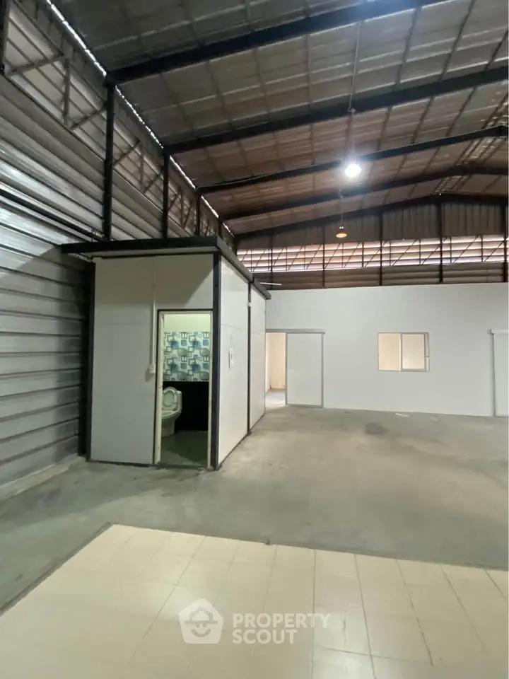 Spacious industrial warehouse with high ceilings and office space, ideal for storage or manufacturing.