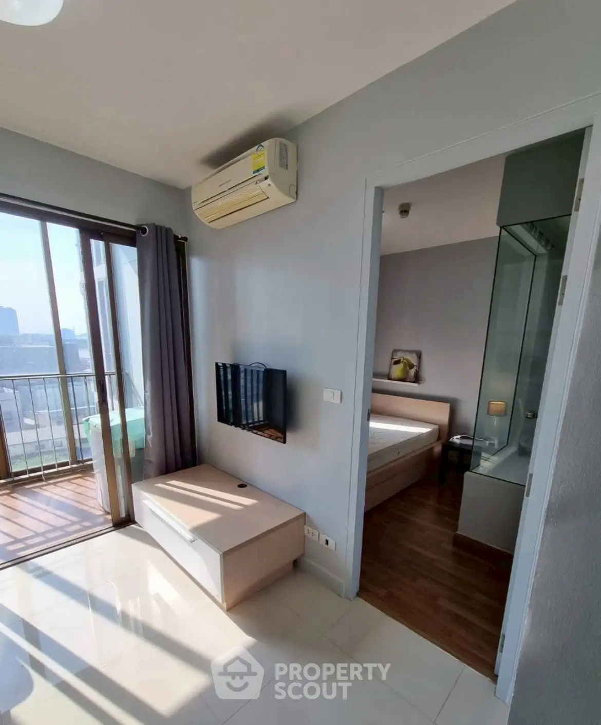 Modern apartment with balcony and bedroom view, featuring sleek design and natural light.
