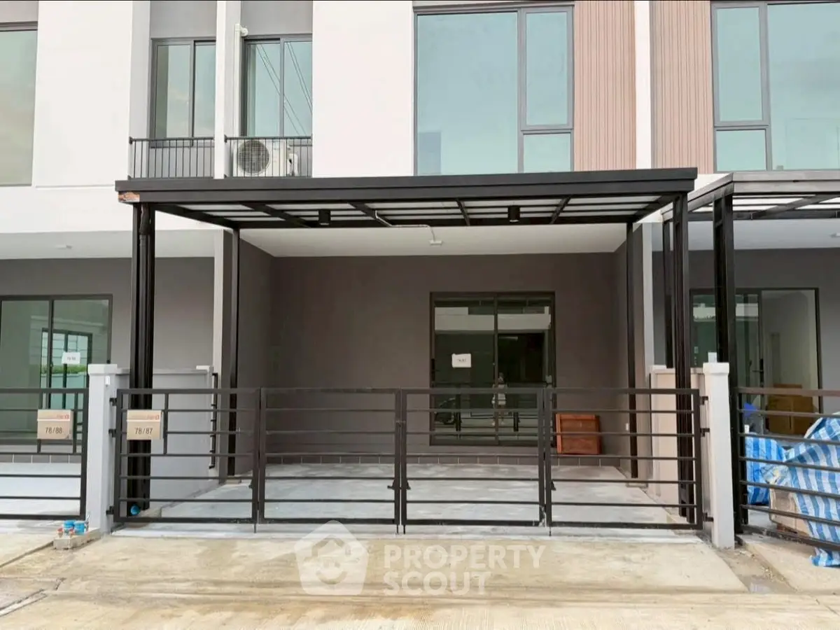 Modern townhouse exterior with sleek design and spacious parking area.