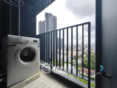 High-rise balcony with washing machine and city skyline view
