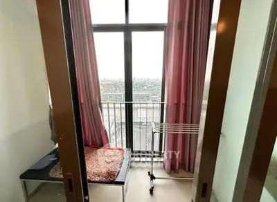 Cozy balcony with city view and pink curtains in modern apartment