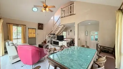 Spacious living room with high ceiling and modern decor in a bright, airy home.