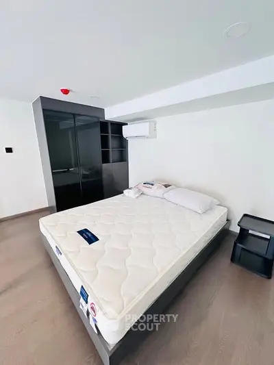 Modern bedroom with sleek design, featuring a comfortable bed and built-in wardrobe, perfect for urban living.