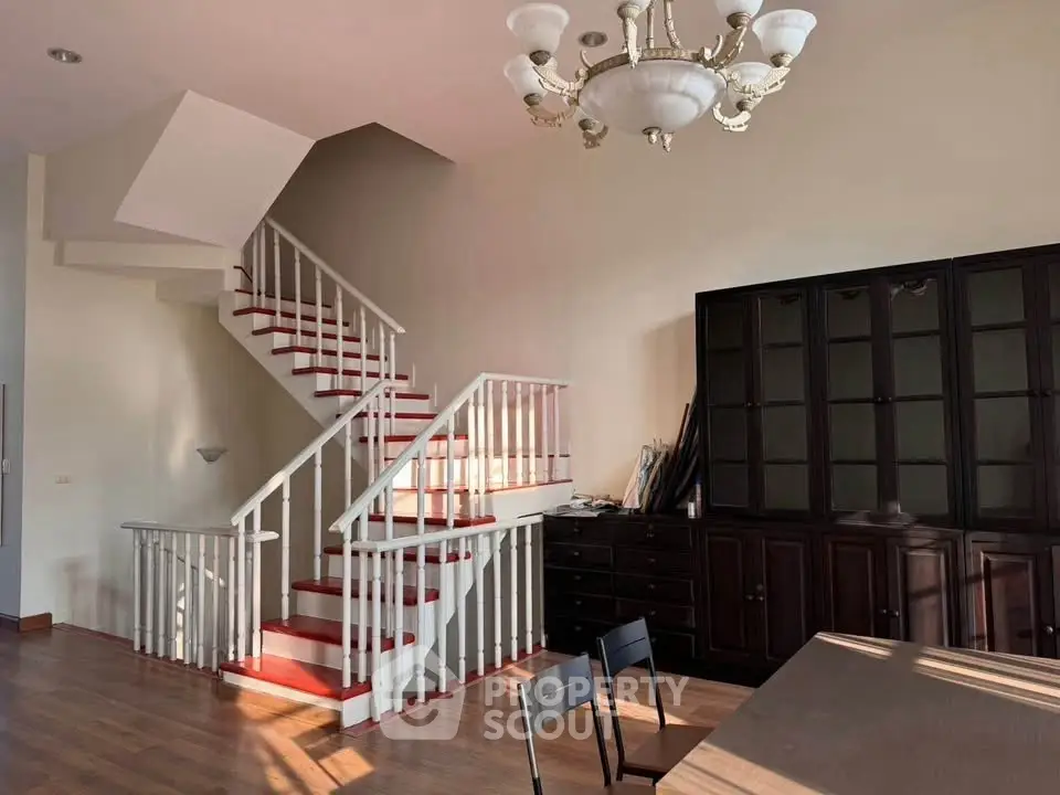 Spacious living room with elegant staircase and wooden flooring
