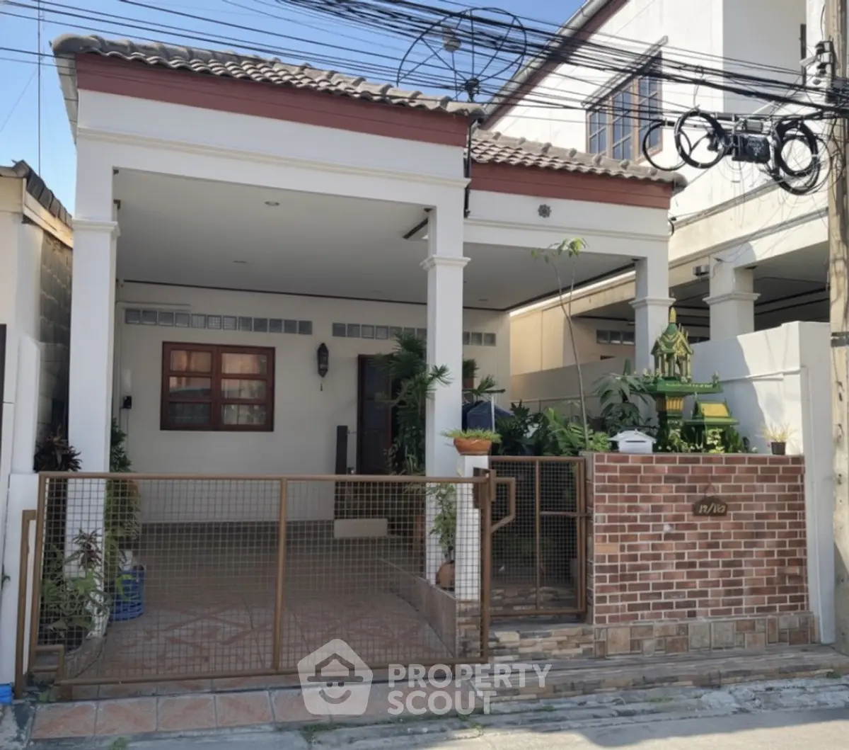 Charming suburban house with covered carport and brick fence in a quiet neighborhood.