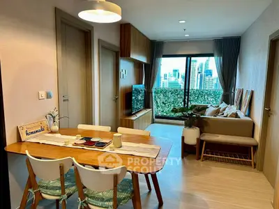 Modern living room with city view, stylish furniture, and cozy dining area.