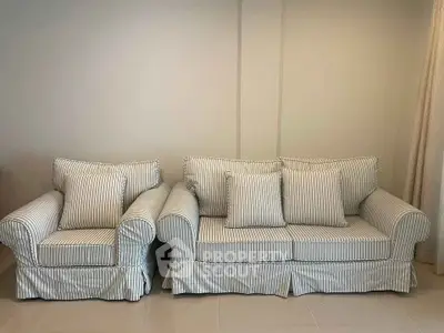 Elegant striped sofa set in a modern living room with neutral tones.