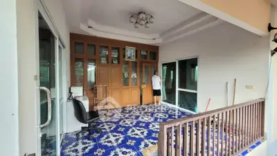 Spacious balcony with decorative blue tiles and wooden accents, ideal for relaxation and gatherings.