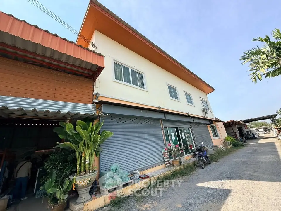 Charming two-story building with large windows and a spacious exterior, perfect for commercial or residential use.