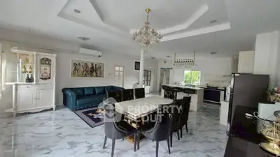 Luxurious open-plan living and dining area with elegant chandelier and modern furnishings.