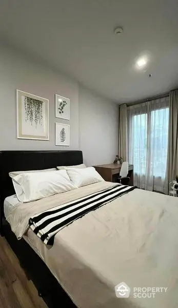 Elegant bedroom with a large comfortable bed, chic wall art, and floor-to-ceiling curtains, perfect for restful nights and stylish living.