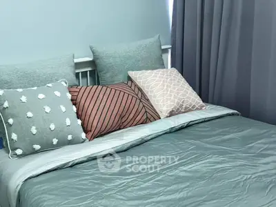 Cozy bedroom with stylish pillows and soft lighting, perfect for relaxation and comfort.