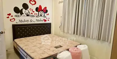Charming bedroom with Mickey and Minnie wall art, cozy bed, and elegant curtains.