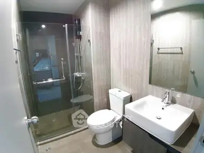 Modern bathroom with glass shower and sleek fixtures in a contemporary apartment.