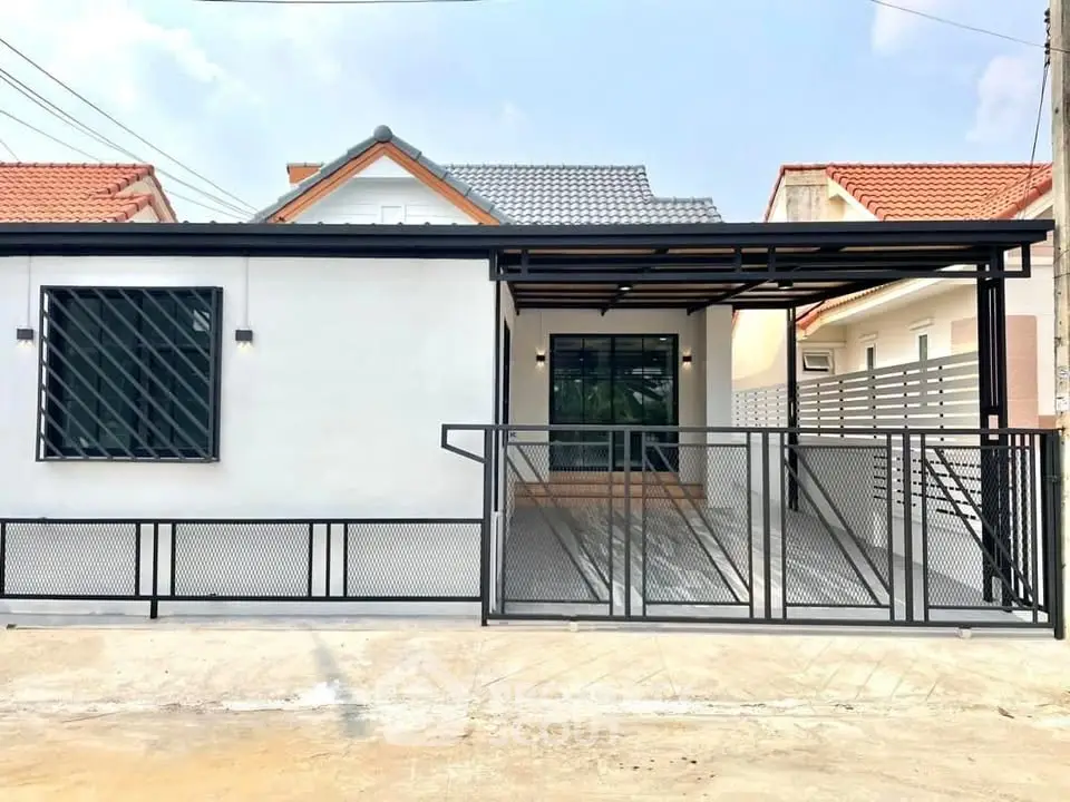 Modern single-story house with sleek metal gate and driveway