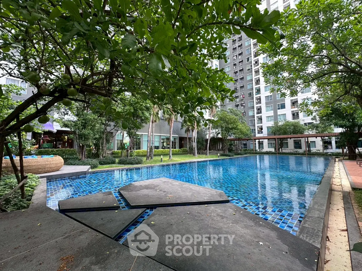 Luxurious residential pool surrounded by lush greenery and modern architecture, perfect for relaxation and leisure.