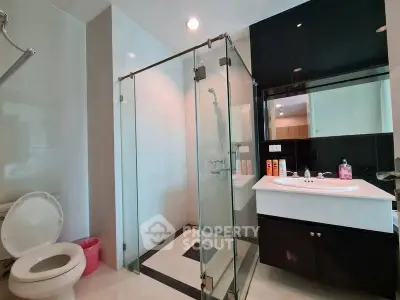 Modern bathroom with glass shower and sleek black vanity