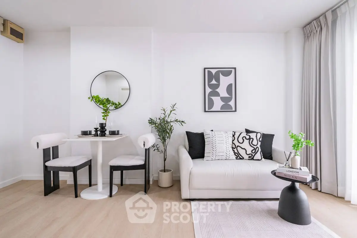 Modern living room with stylish decor and natural light, featuring a cozy sofa and chic dining area.