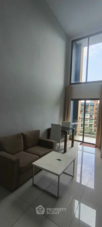 Modern living room with high ceiling and large windows offering a stunning view.