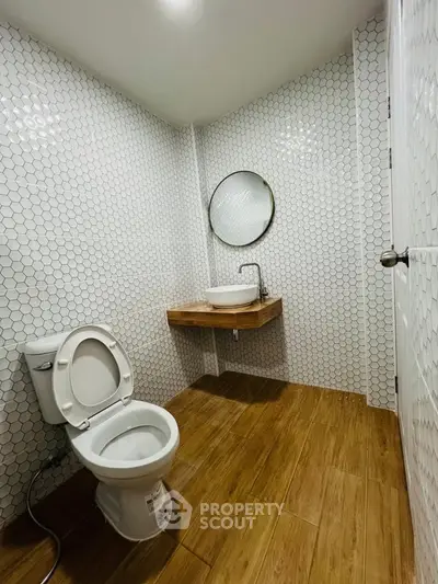 Modern bathroom with hexagonal tiles and wooden flooring
