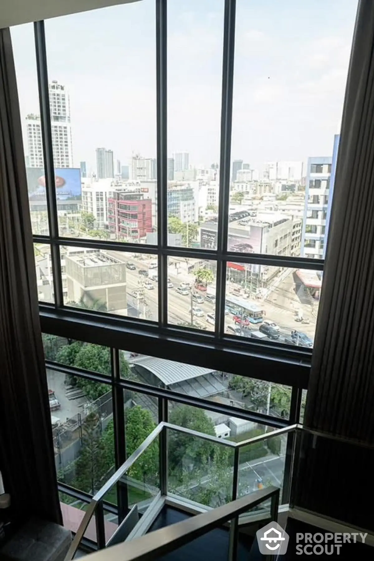 Stunning cityscape view from modern apartment window with sleek staircase