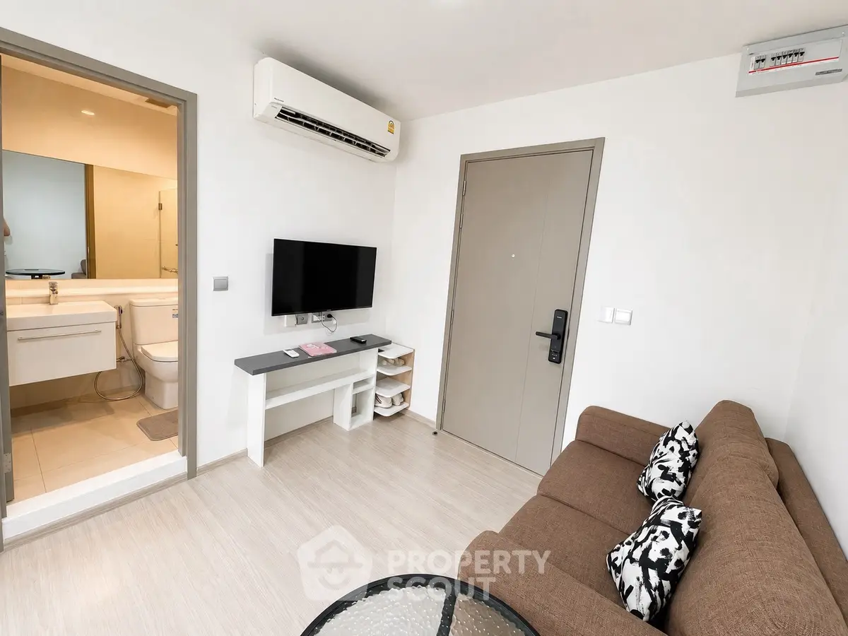 Modern living room with air conditioning and stylish decor, adjacent to a sleek bathroom.