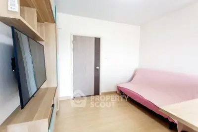 Cozy living room with modern TV setup and comfortable seating in a bright apartment.