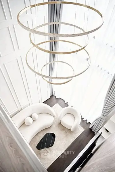 Luxurious modern living room with high ceilings and elegant chandelier