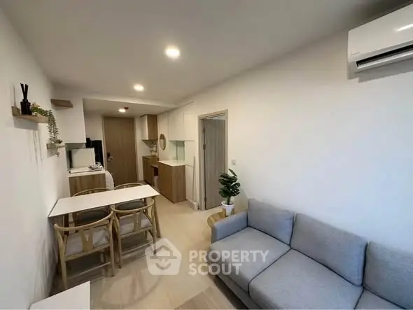 Modern living room with cozy sofa and dining area in open layout apartment.