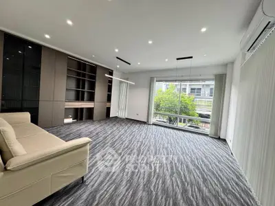 Spacious modern living room with large window and stylish carpet flooring